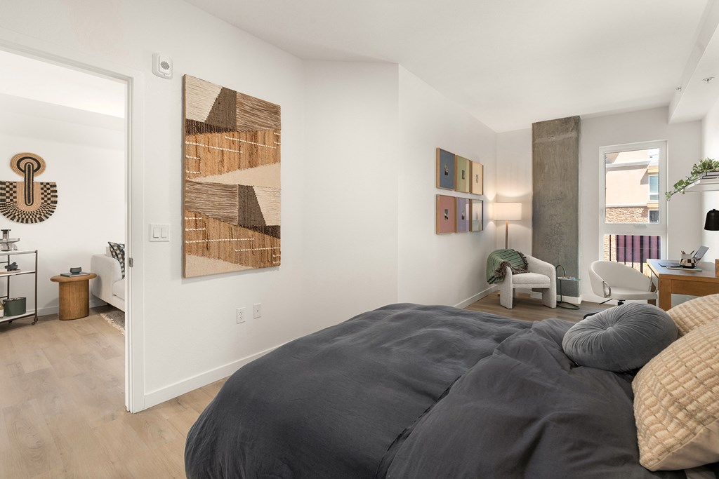 A bedroom with a large bed and a painting on the wall.
