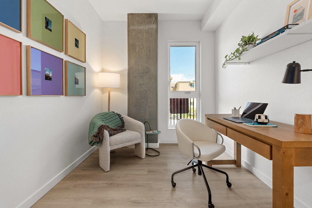 A room with a desk, chair, and a couch.