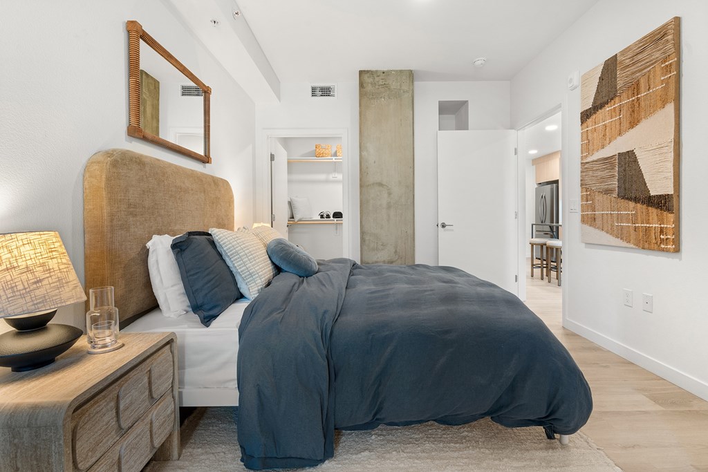 A bedroom with a large bed and a painting on the wall.
