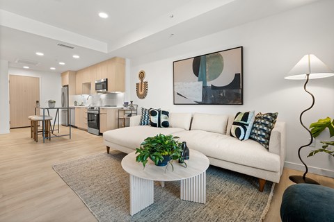 A modern living room with a white sofa and a coffee table.