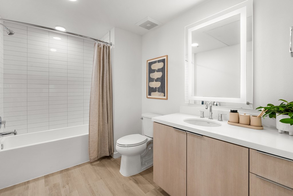 A white bathroom with a toilet, sink, and shower.