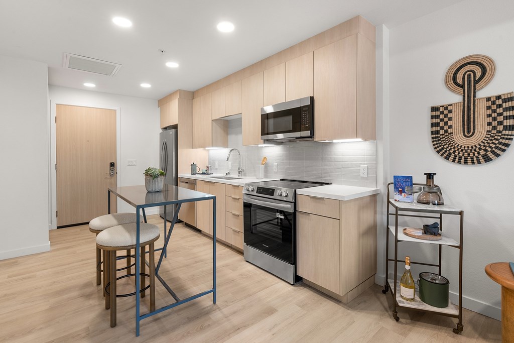 A modern kitchen with a wooden table and chairs.