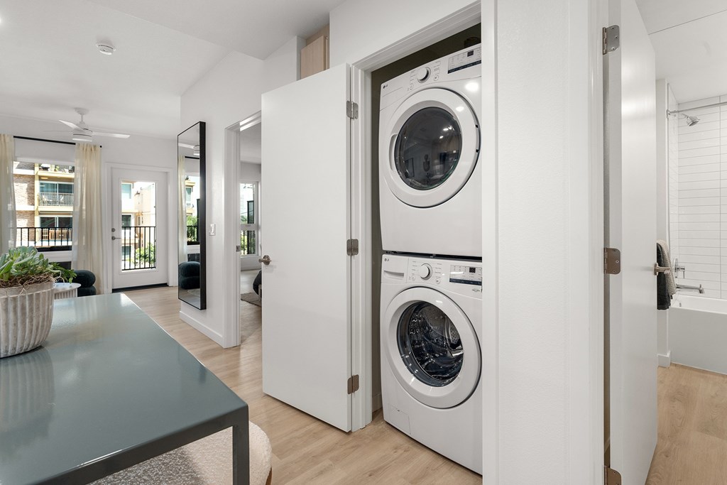 A modern laundry room with a washer and dryer built into the wall.
