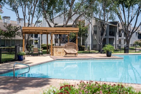 A pool with a bench and a canopy.