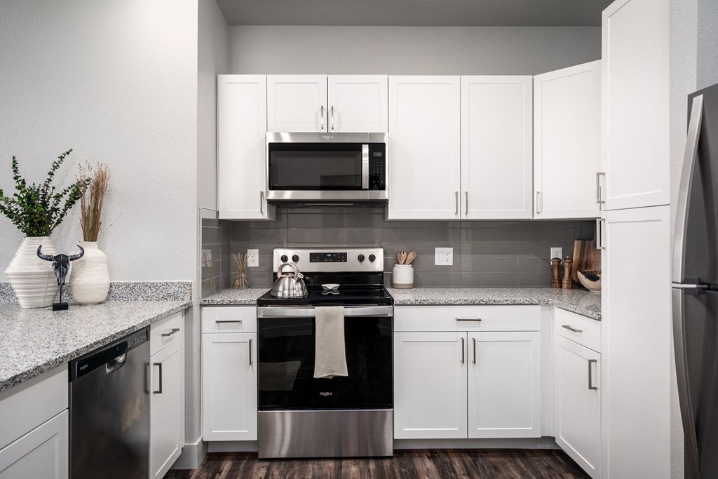 a kitchen with white cabinets and stainless steel appliances