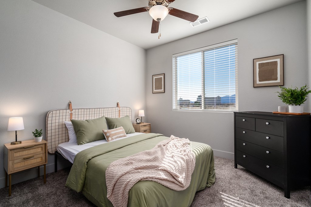 an empty bedroom with a bed and a ceiling fan