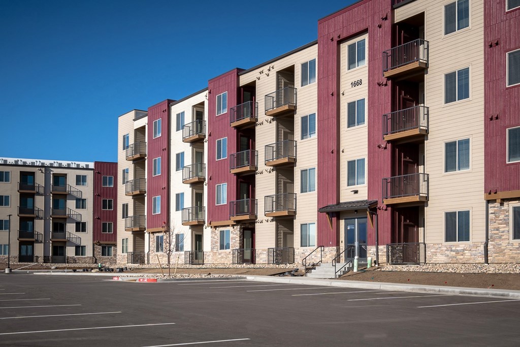 a row of apartment buildings in a parking lot