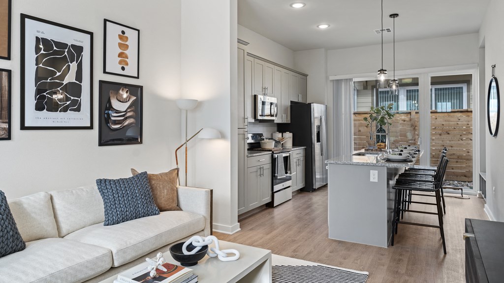 a living room and kitchen with a couch and a table