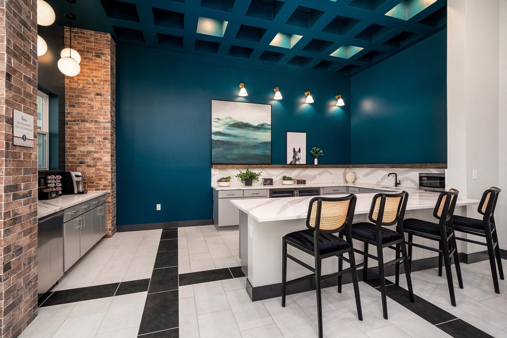 a kitchen with blue walls and a white counter with chairs