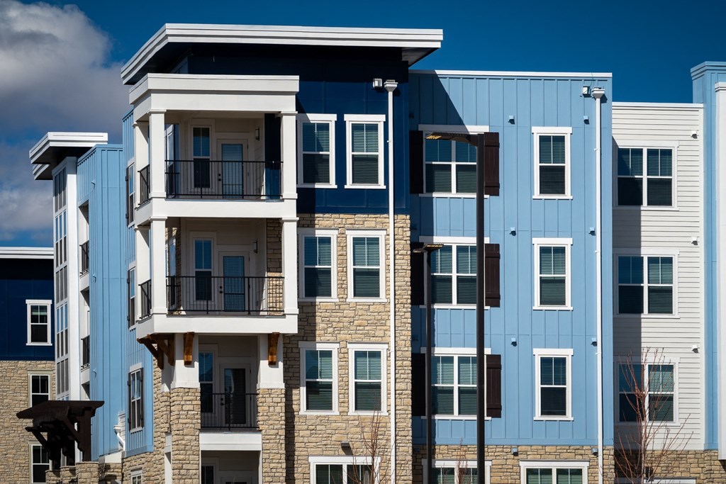 an image of an apartment building with brick and blue exterior