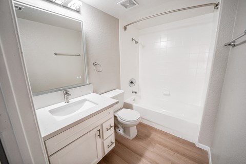 A white bathroom with a sink, toilet, and bathtub.