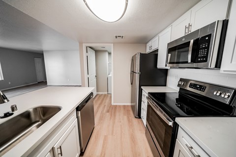 A kitchen with black appliances and white cabinets.