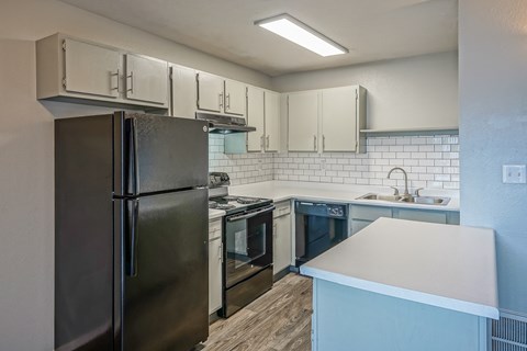 an empty kitchen with stainless steel appliances and white cabinets