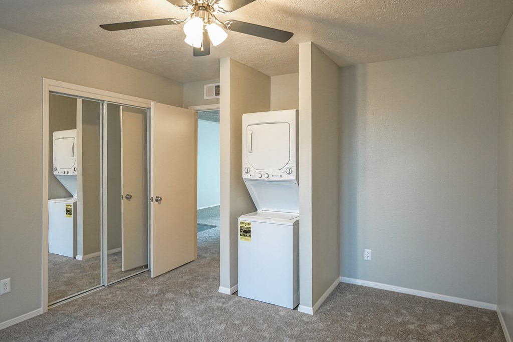 an empty room with a washer and dryer in an empty laundry room