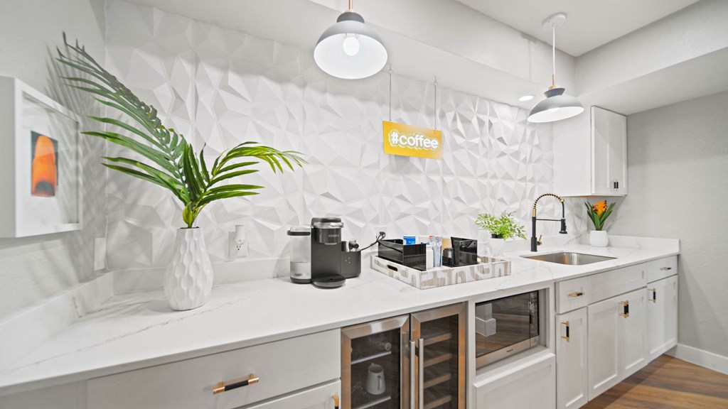 a white kitchen with white cabinets and a green plant in a white vase