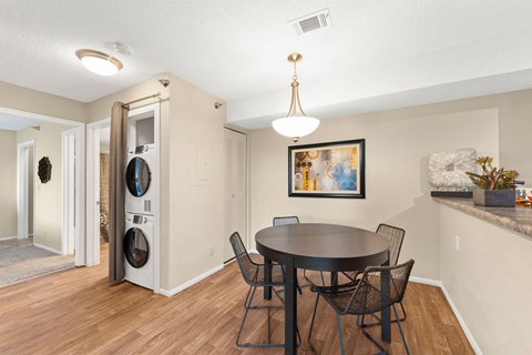 A dining room with a round table and chairs.