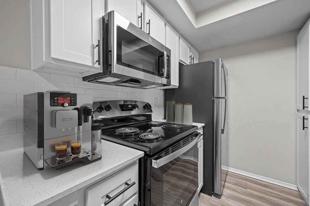 A modern kitchen with a black stove top oven and a black refrigerator.
