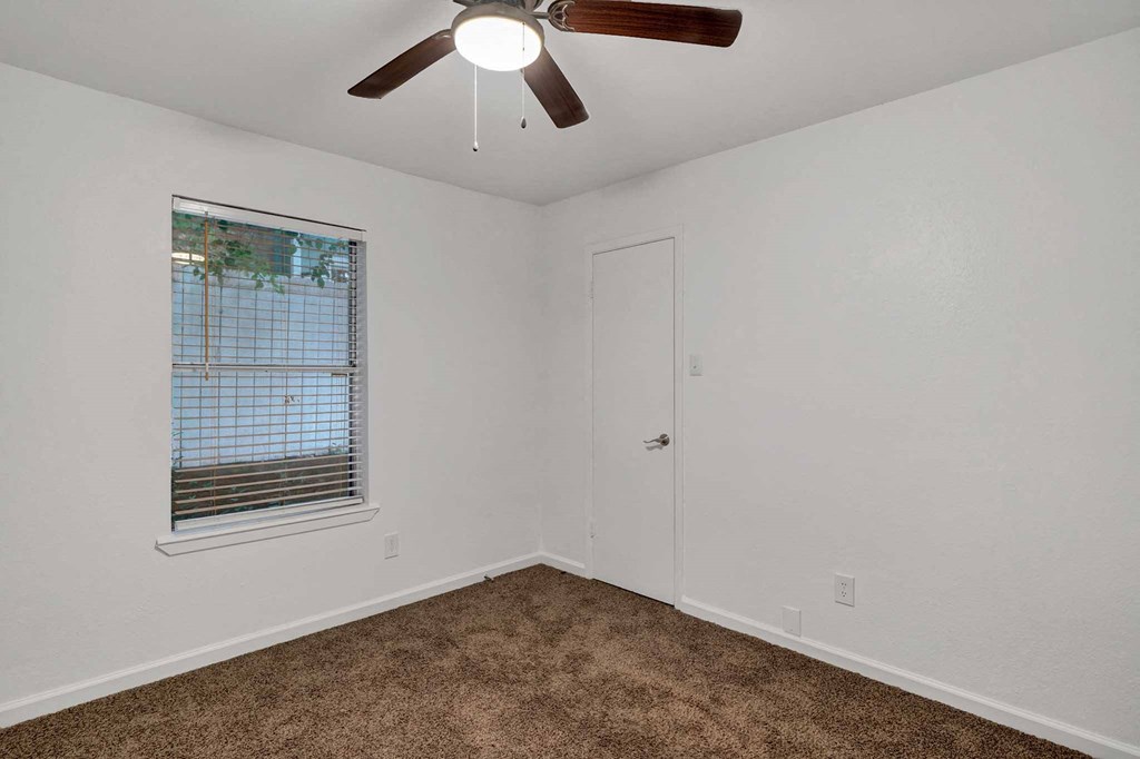 a bedroom with a ceiling fan and a window