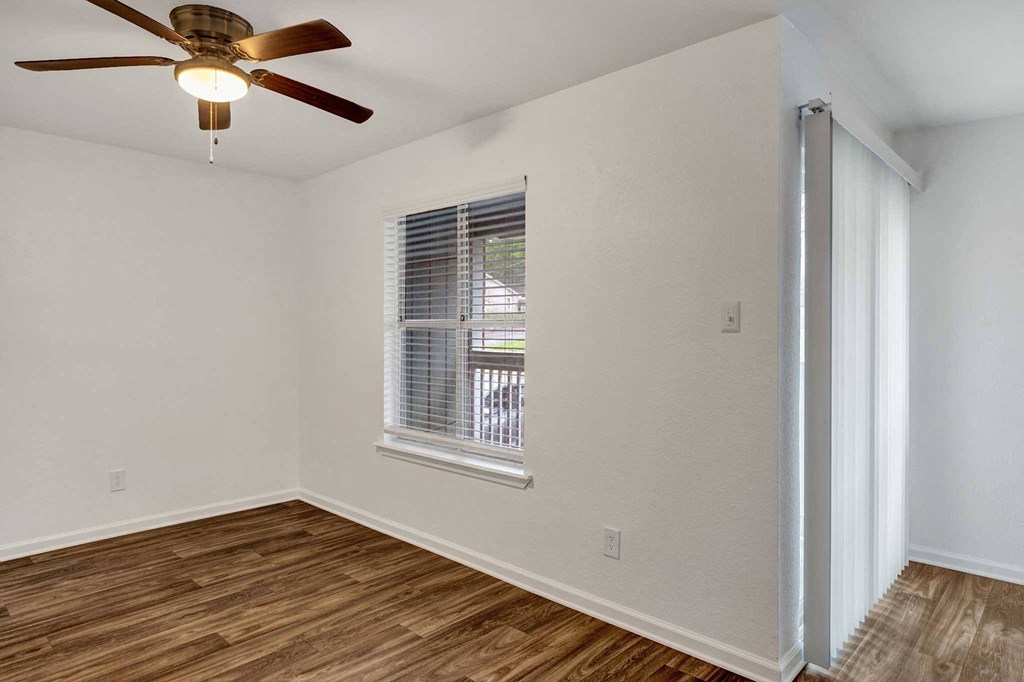 a bedroom with hardwood floors and a ceiling fan