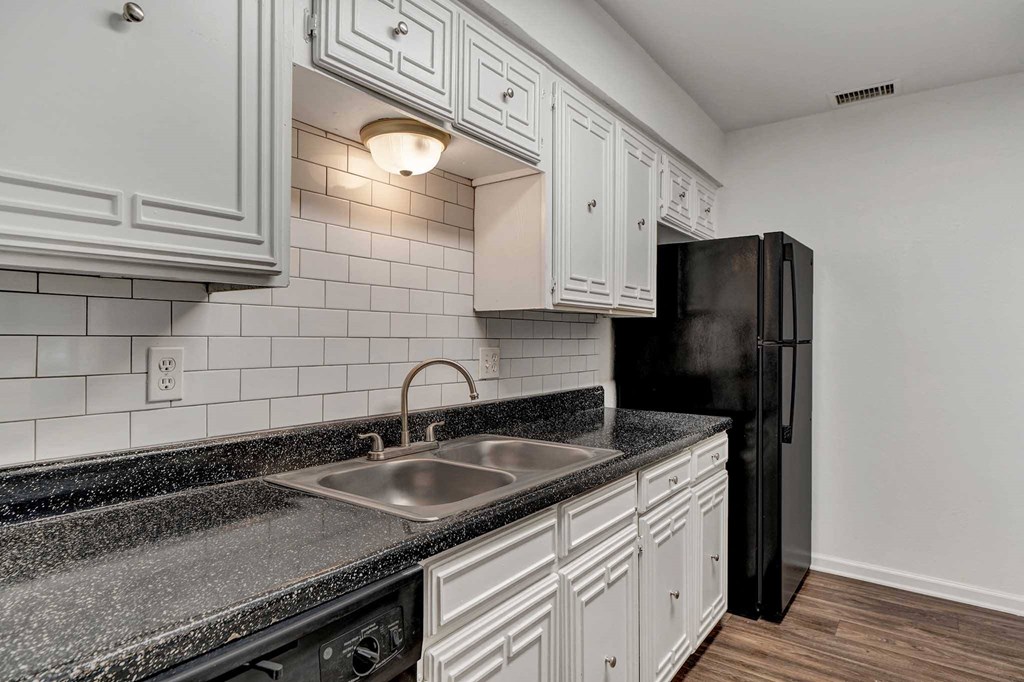 a kitchen with white cabinets and black appliances