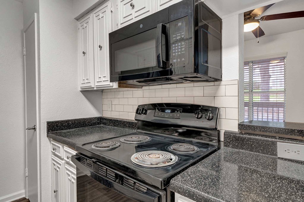 a kitchen with a stove top oven next to a microwave