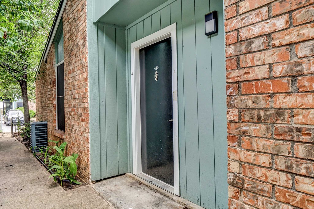 a green door with a white frame on a brick building