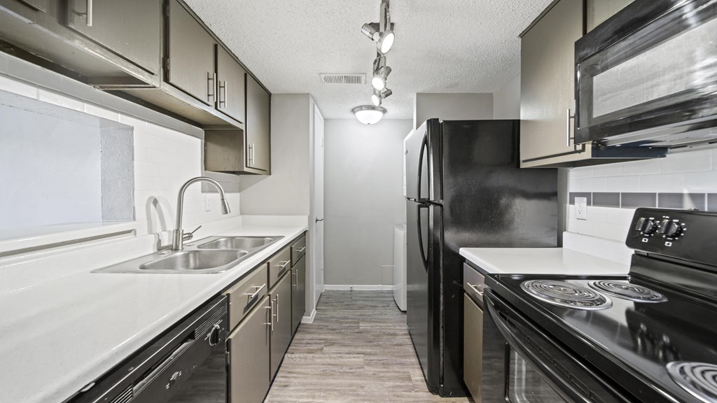 a kitchen with black appliances and white countertops