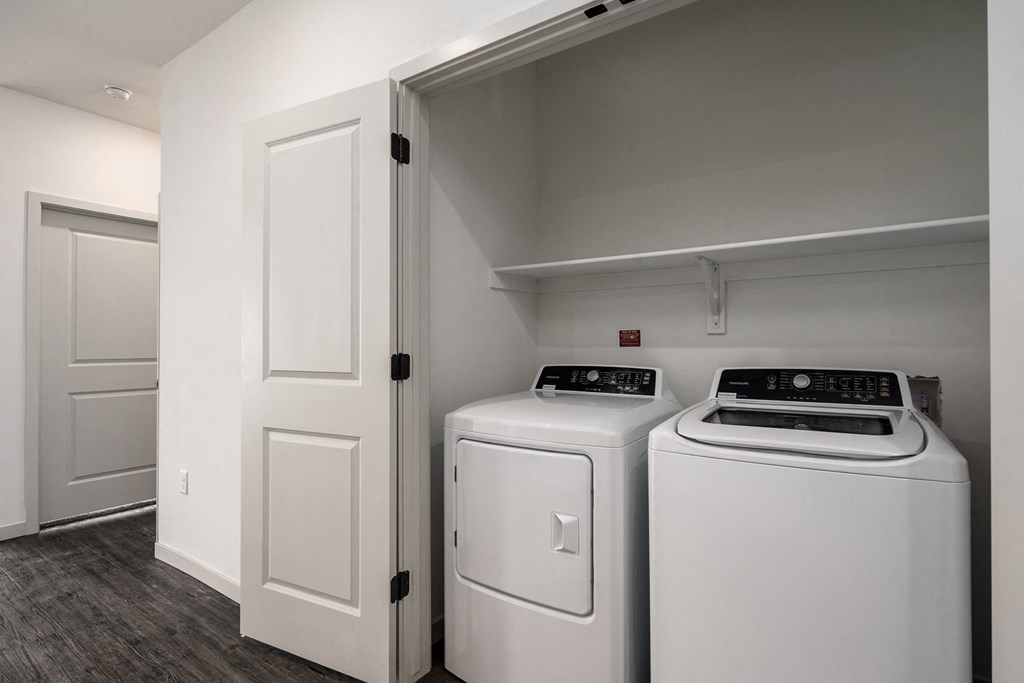 a white washer and dryer in a laundry room with white doors
