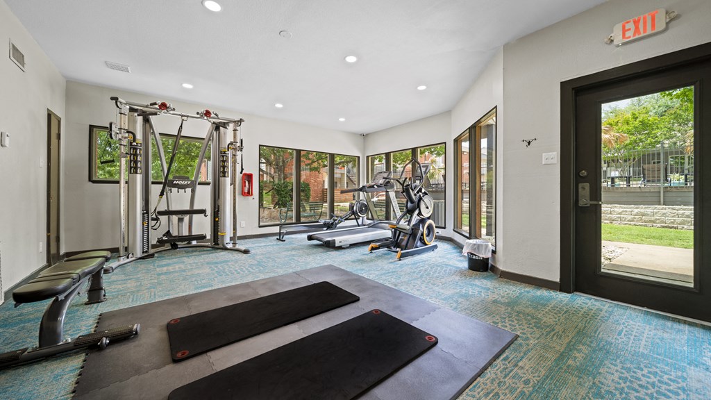 a home gym with exercise equipment and windows