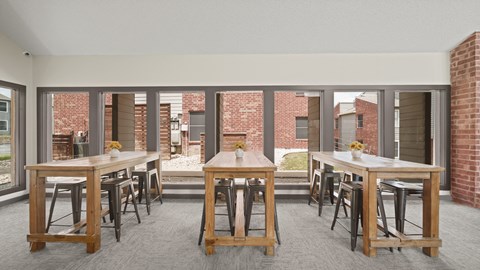 a large open room with tables and chairs and a brick building in the background