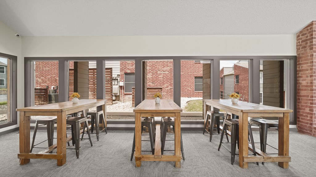 a large open room with tables and chairs and a brick building in the background