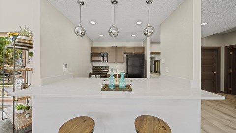 a kitchen with a white counter top and a living room