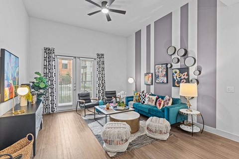 A living room with a blue couch and a ceiling fan.