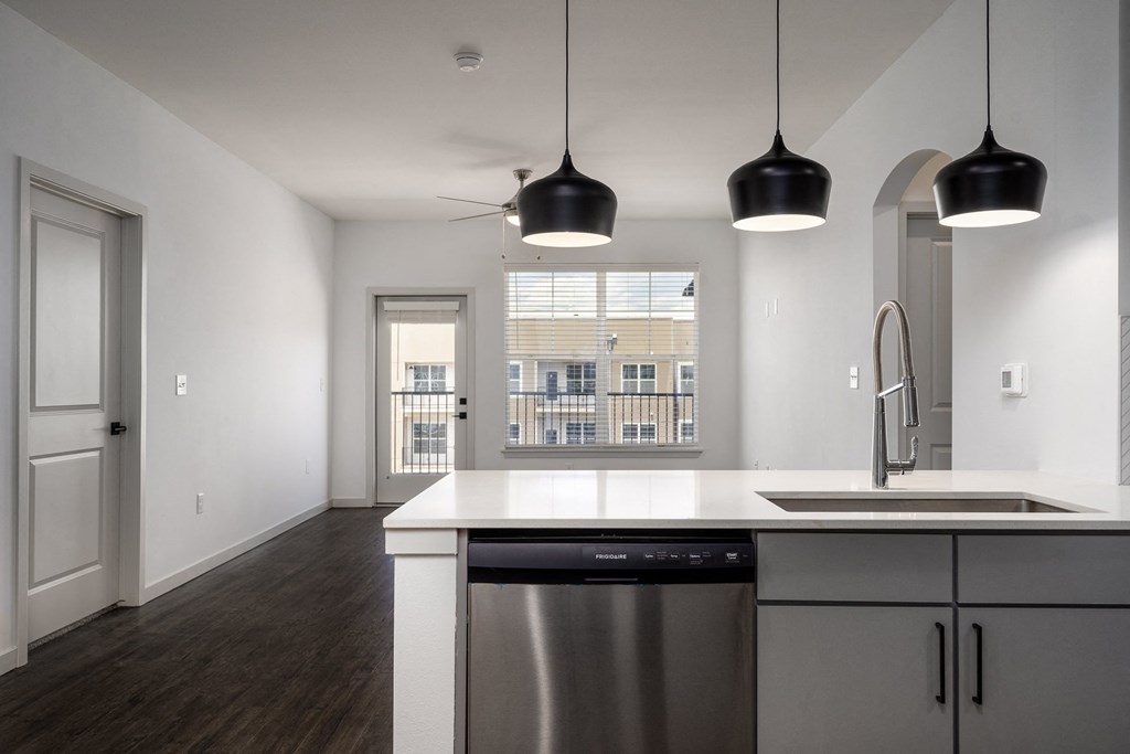 a kitchen and living room with a sink and a window