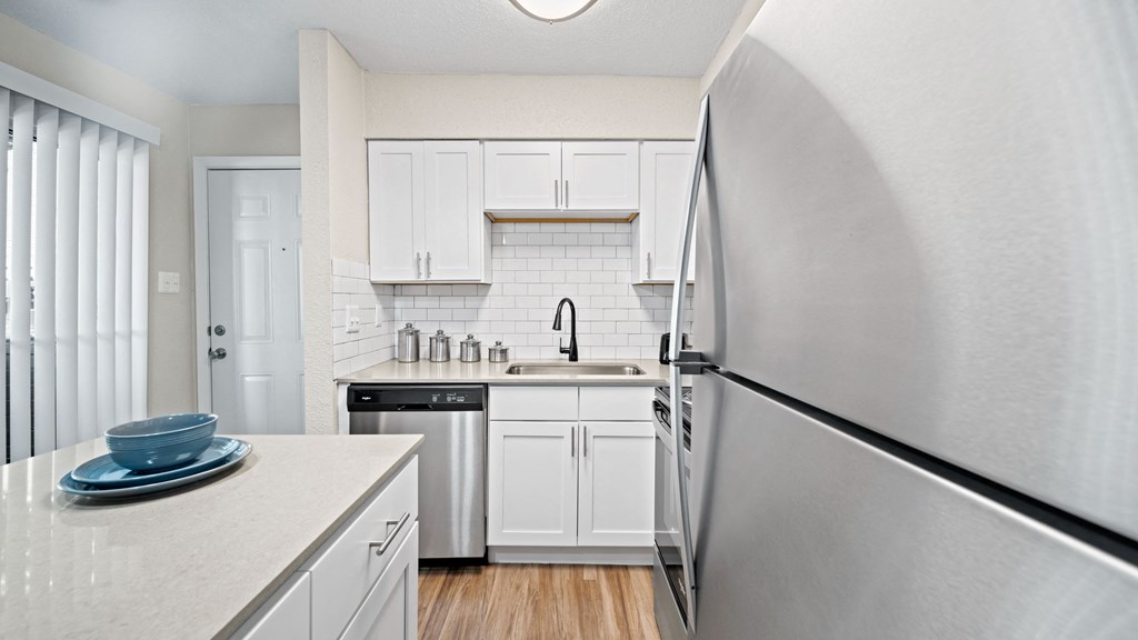 a kitchen with white cabinets and stainless steel appliances