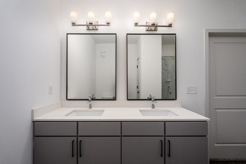 a bathroom with two sinks and two mirrors