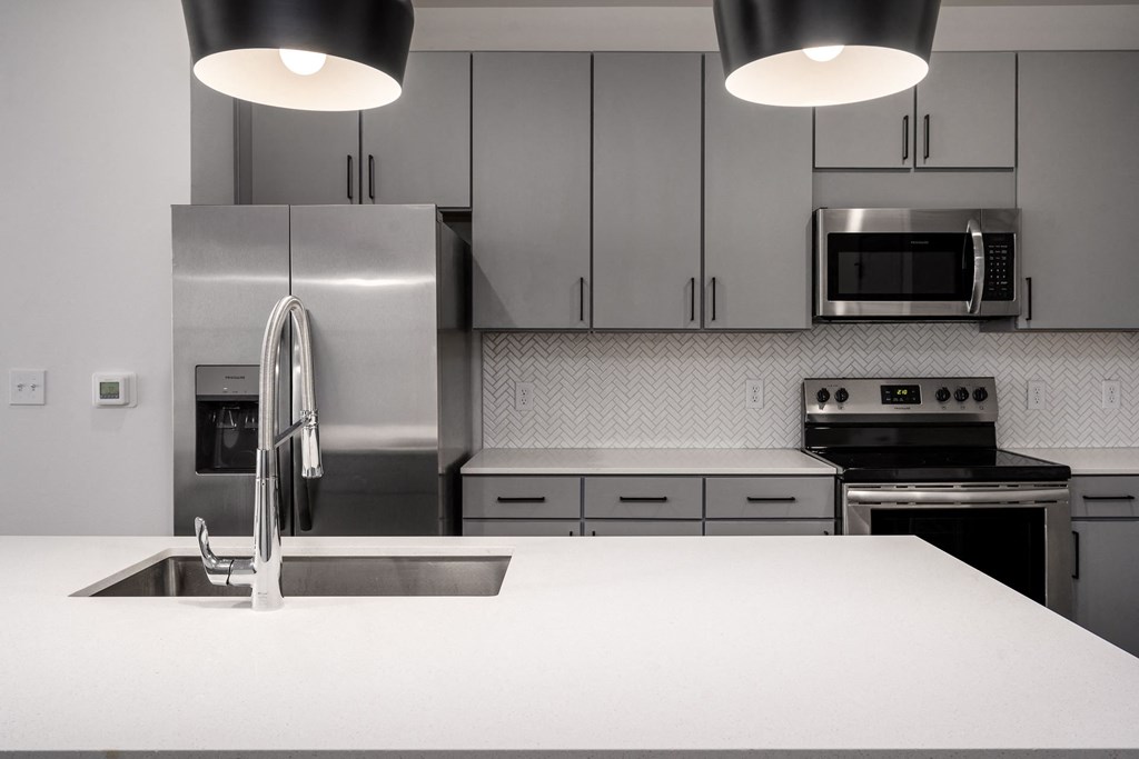 a kitchen with stainless steel appliances and white counter tops