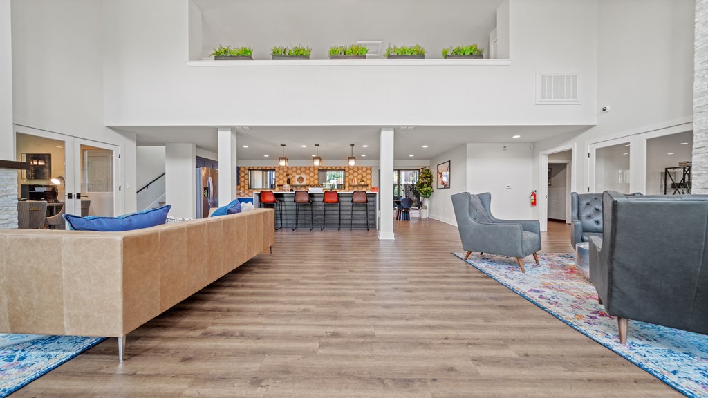 a view of the clubhouse with couches chairs and a bar in the background