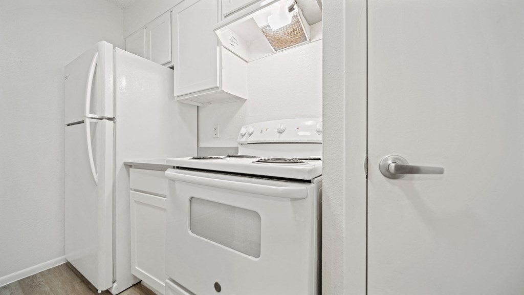 a kitchen with white appliances and white cabinets