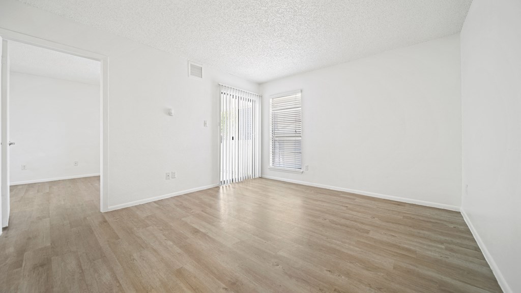 a bedroom with hardwood floors and white walls