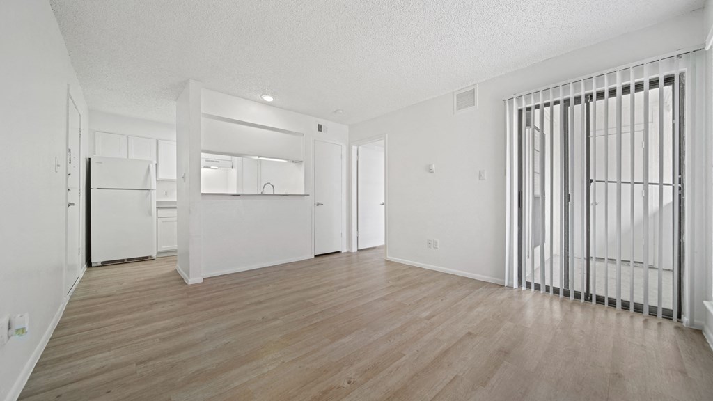 a bedroom with hardwood flooring and white walls