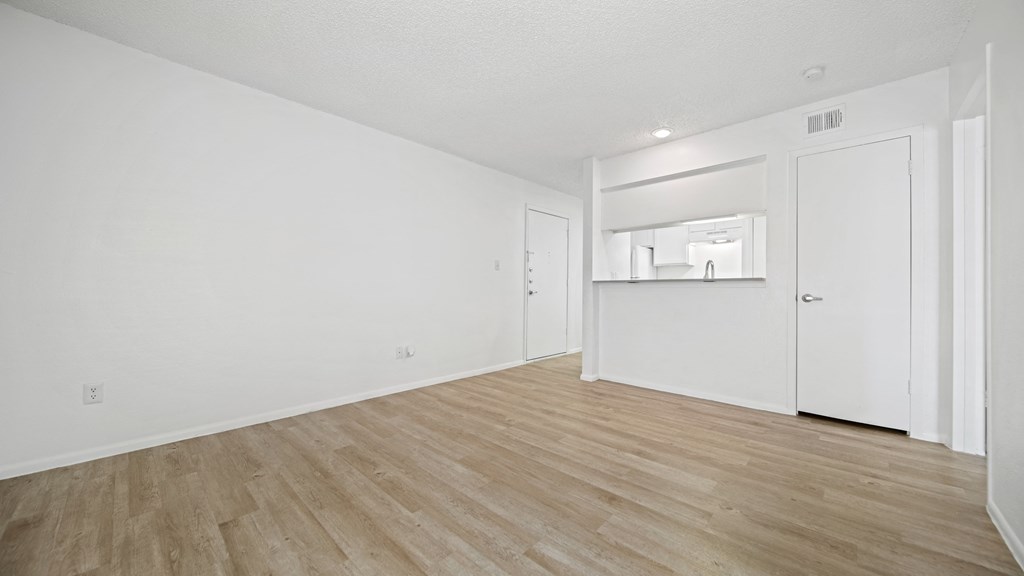 a bedroom with a hardwood floor and white walls