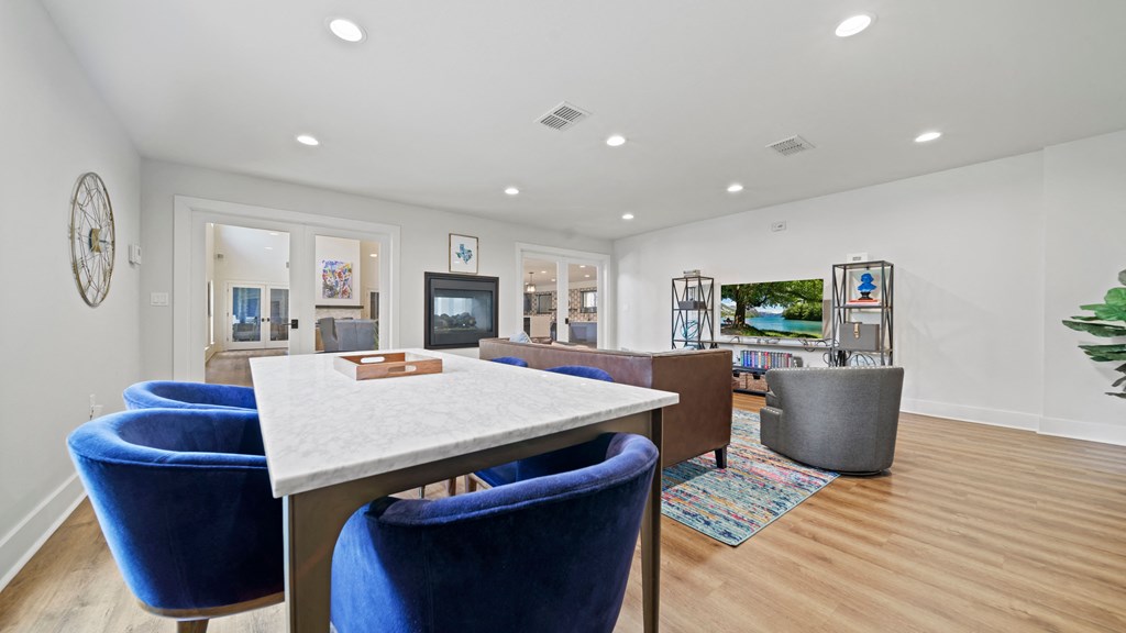 a living room with a table and chairs and a television in the background
