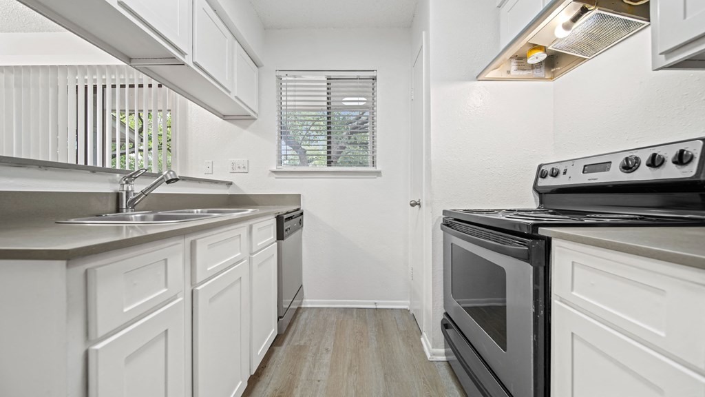 a kitchen with white cabinets and stainless steel appliances