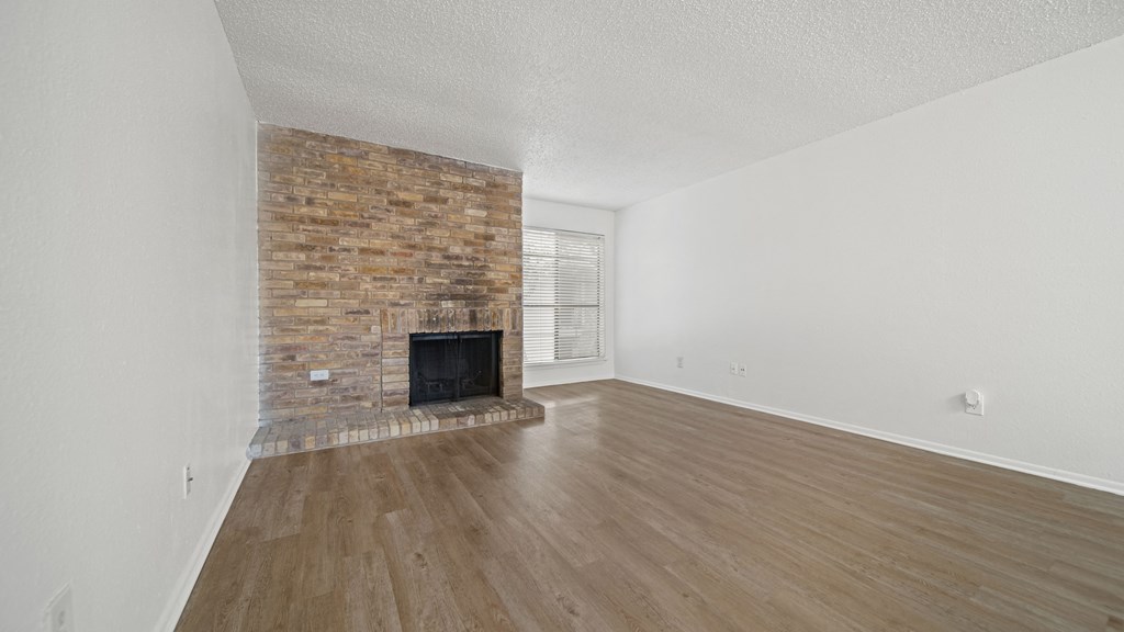 a bedroom with a fireplace and hardwood floors