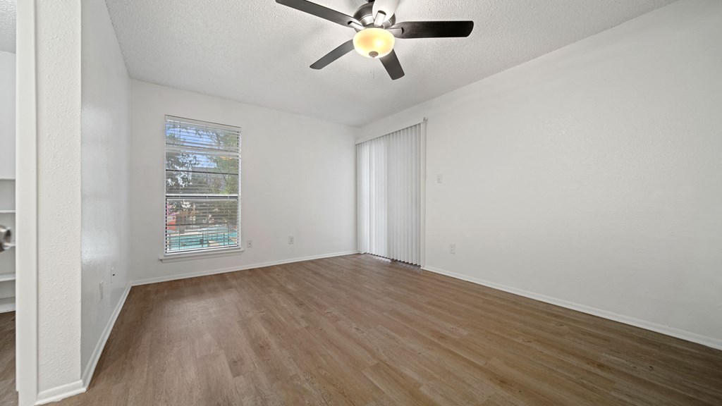a bedroom with hardwood floors and a ceiling fan