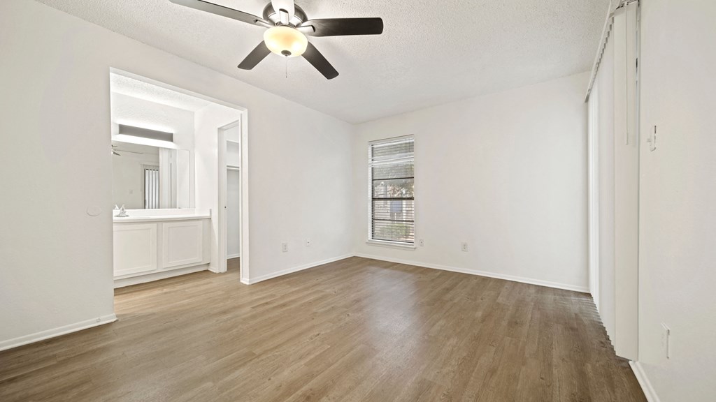 a bedroom with hardwood floors and a ceiling fan
