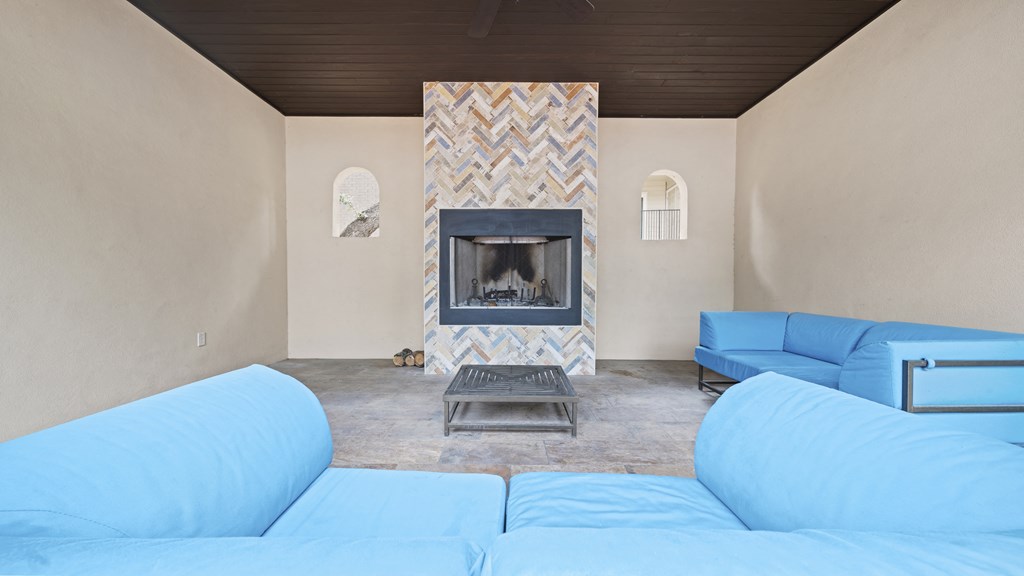 a living room with a fireplace and blue couches
