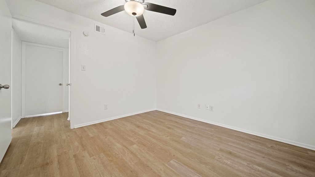 a bedroom with hardwood floors and a ceiling fan