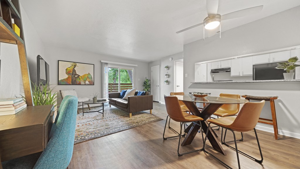 a living and dining room area with a table and chairs and a couch in the background